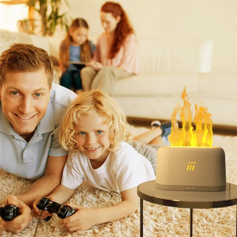Black round flame aroma diffuser humidifier with LED lights and remote control on a table.