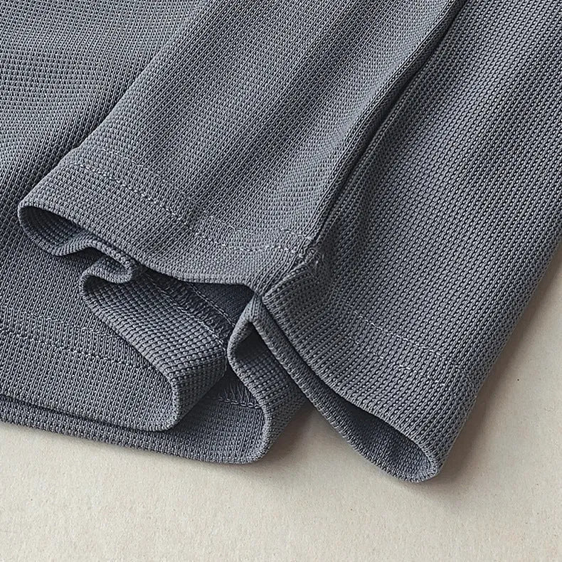 Men's dark grey heavy waffle knit short-sleeved t-shirt on a hanger.