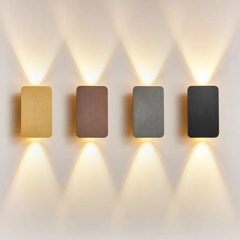 Minimalist modern wall lamp in black finish mounted beside a bed, showing its slim profile.