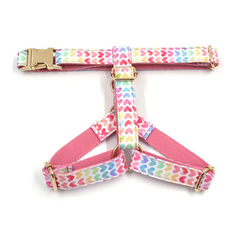 Pink dog harness with gold buckle and heart-shaped stone decoration on a chest and back strap