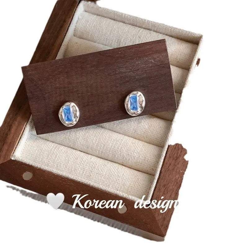 S925 sterling silver earrings with heart-wrapped oval design and blue diamond detail