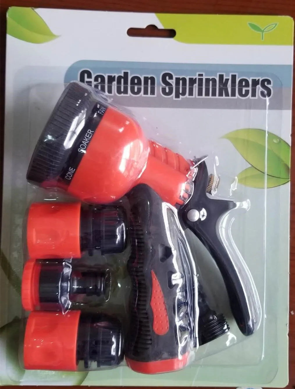 Green metal garden spray gun with sprinkler attachment for watering and cleaning