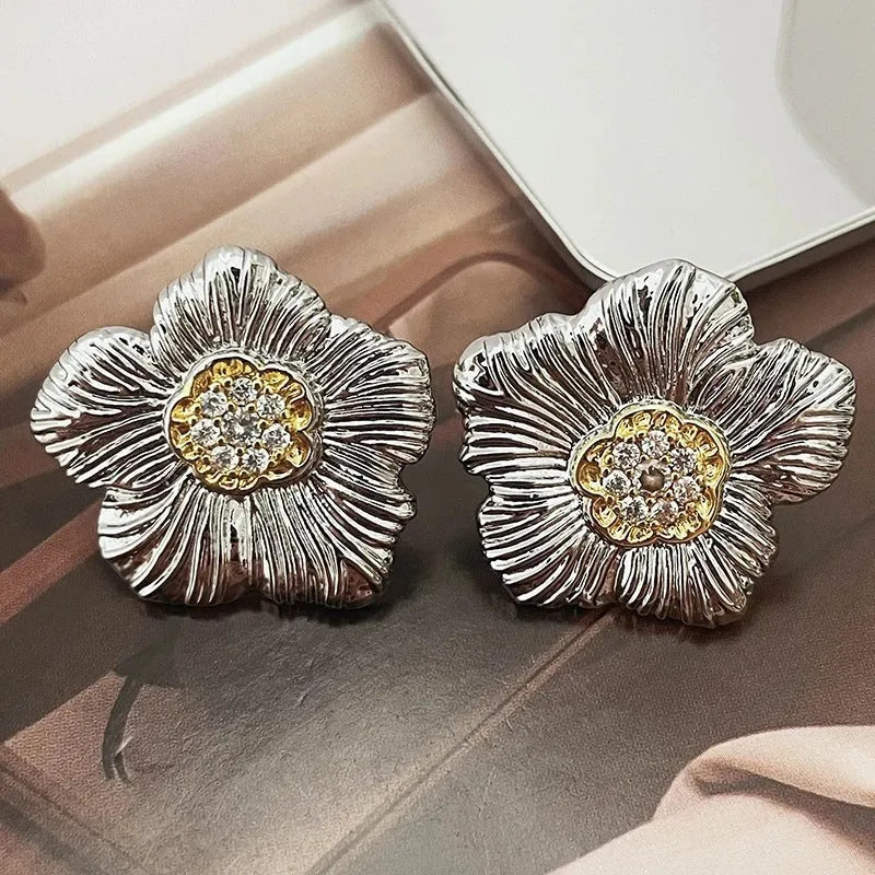 Close-up of retro textured gardenia stud earrings in two-tone copper with floral petal detail.