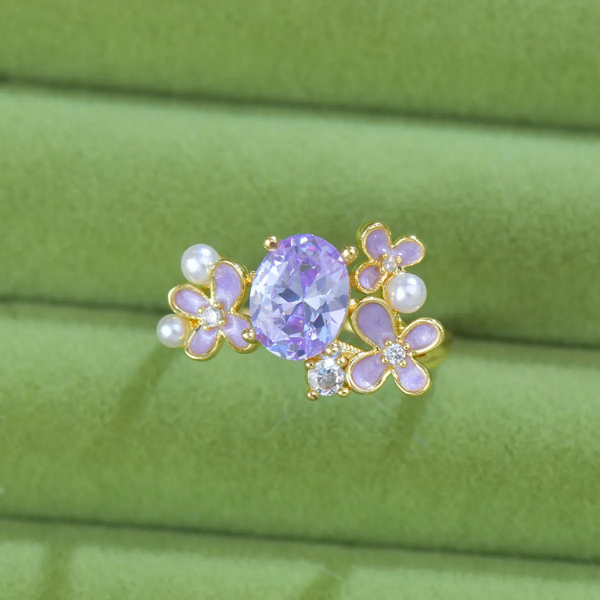 Yellow women's open ring with a flower shape and zircon detailing on a white background.