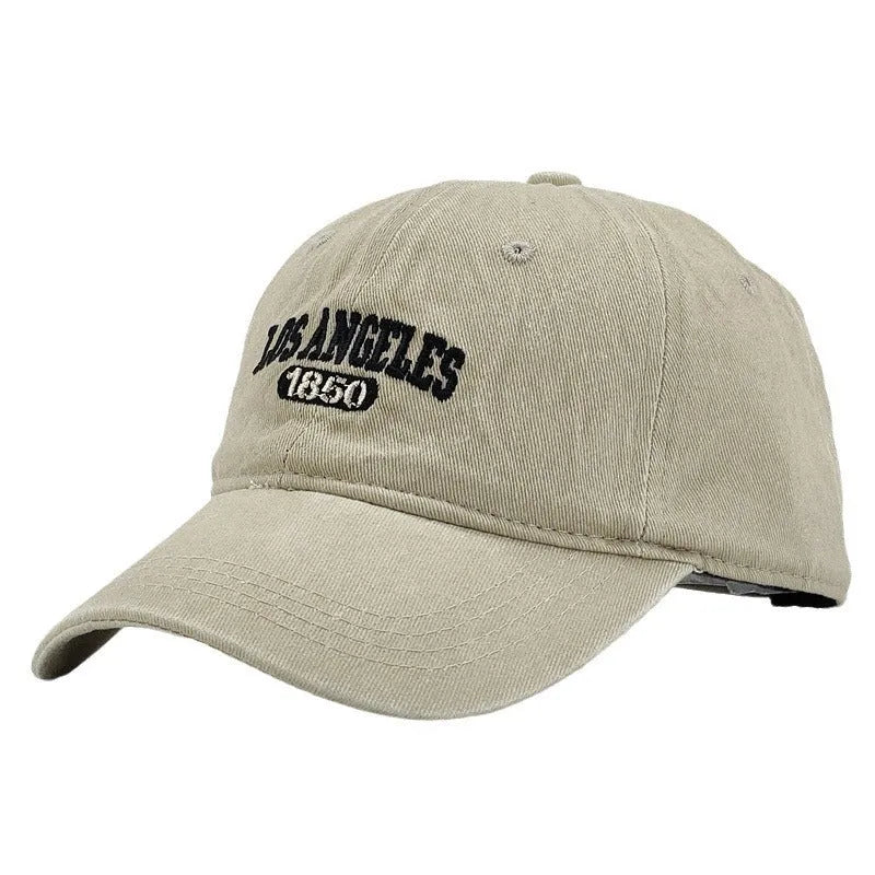 Retro distressed acrylic cap with embroidered letters, shown in beige colour with adjustable strap.