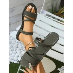 Women's flat cross-strap sandals with buckle closure in black, brown or green colours
