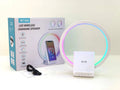 White smart Bluetooth speaker with integrated wireless charging pad and ambience light on a desk.