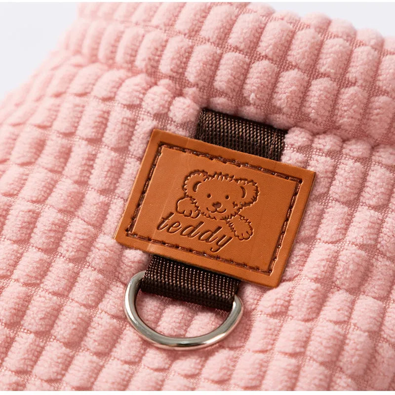 Pink ribbed corduroy dog vest with metal leash ring and bear emblem tag, sizes XS to XXL.