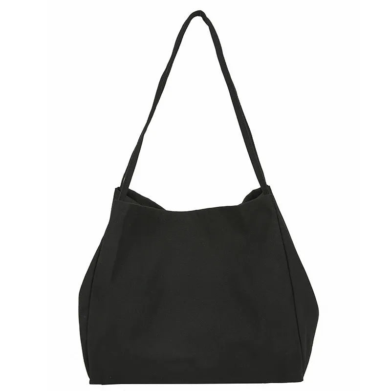 Women's black canvas shopping handbag with double shoulder straps showing internal mobile phone pocket
