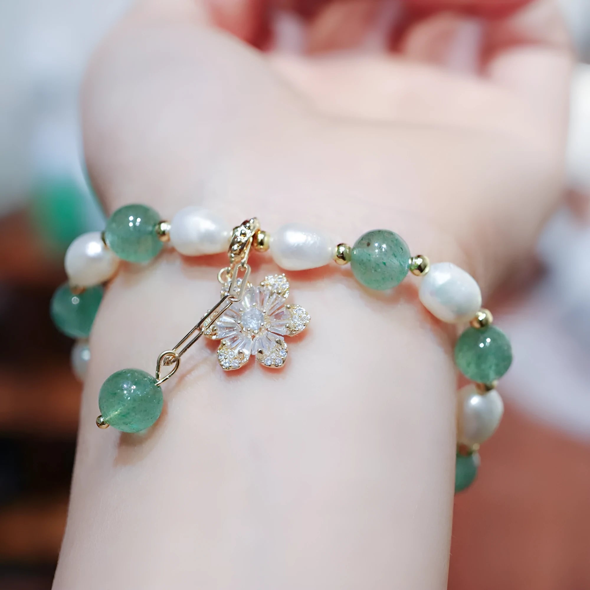 Green freshwater pearl bracelet with Chinese knot design and strawberry pearl hanging detail