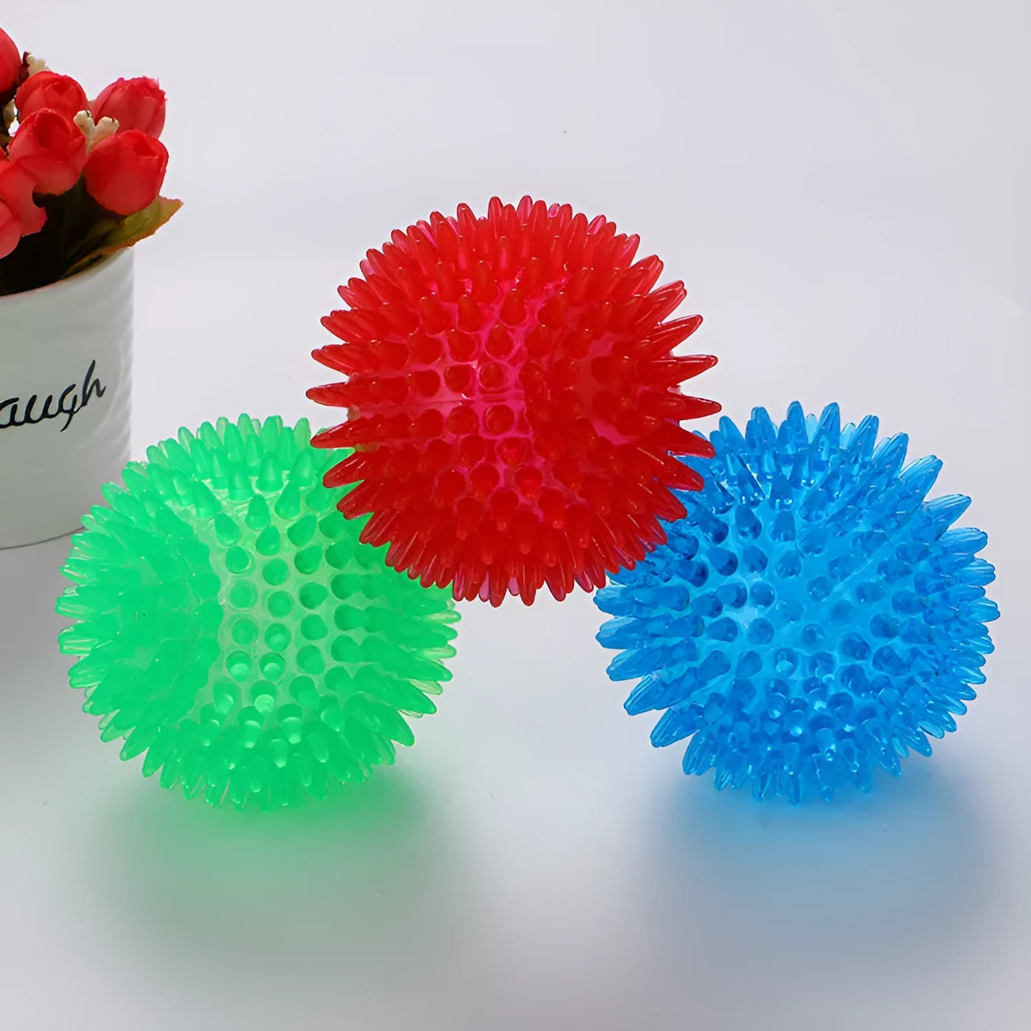 TPR spiky ball squeaker dog toy in red with textured surface for chewing and fetch games