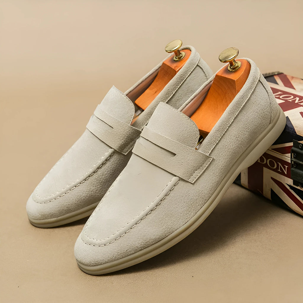 Men's beige leather slip-on shoes with a round toe and mid heel on a rubber sole.