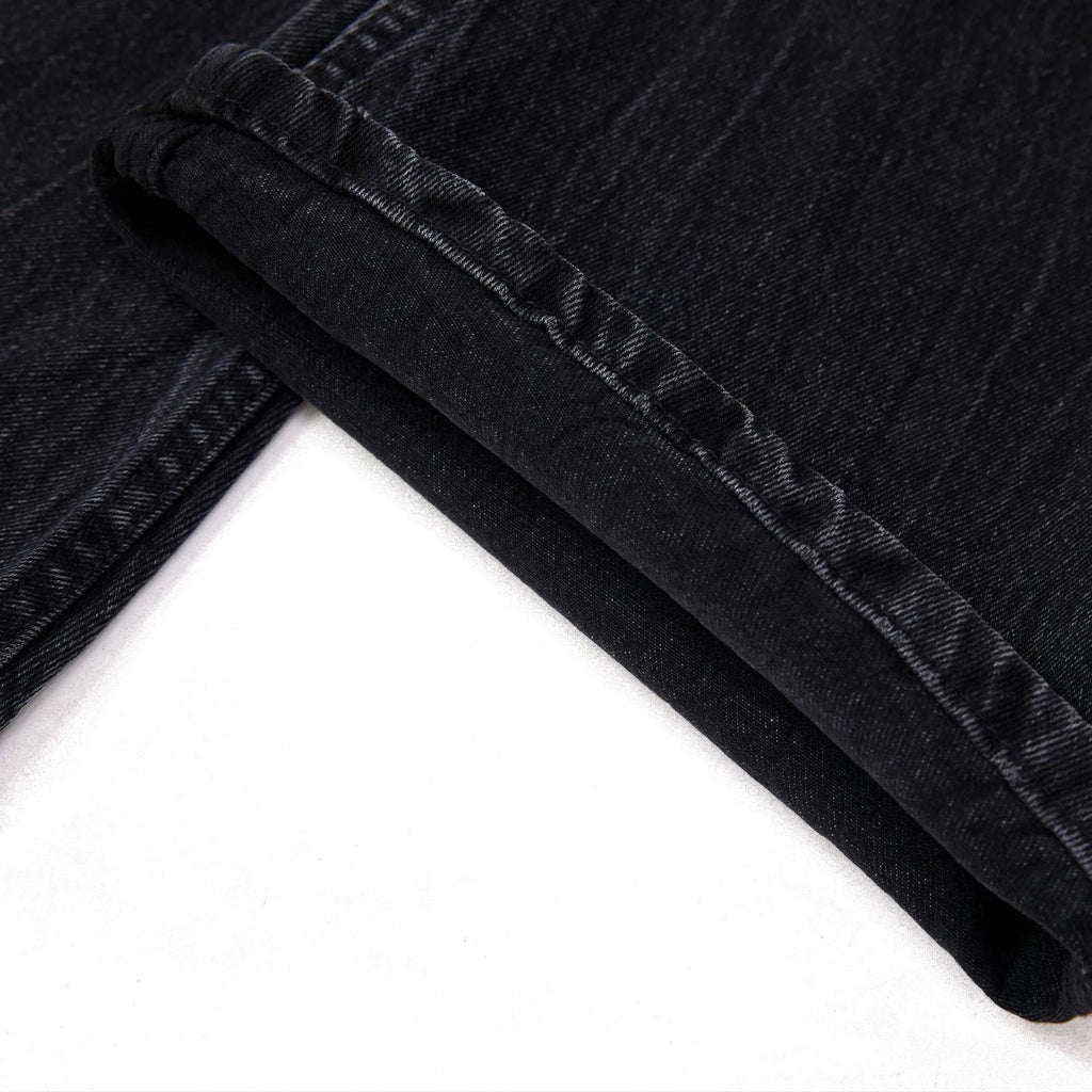 Men's straight-leg black jeans showing an American washed finish with a lightning crack pattern on the legs.