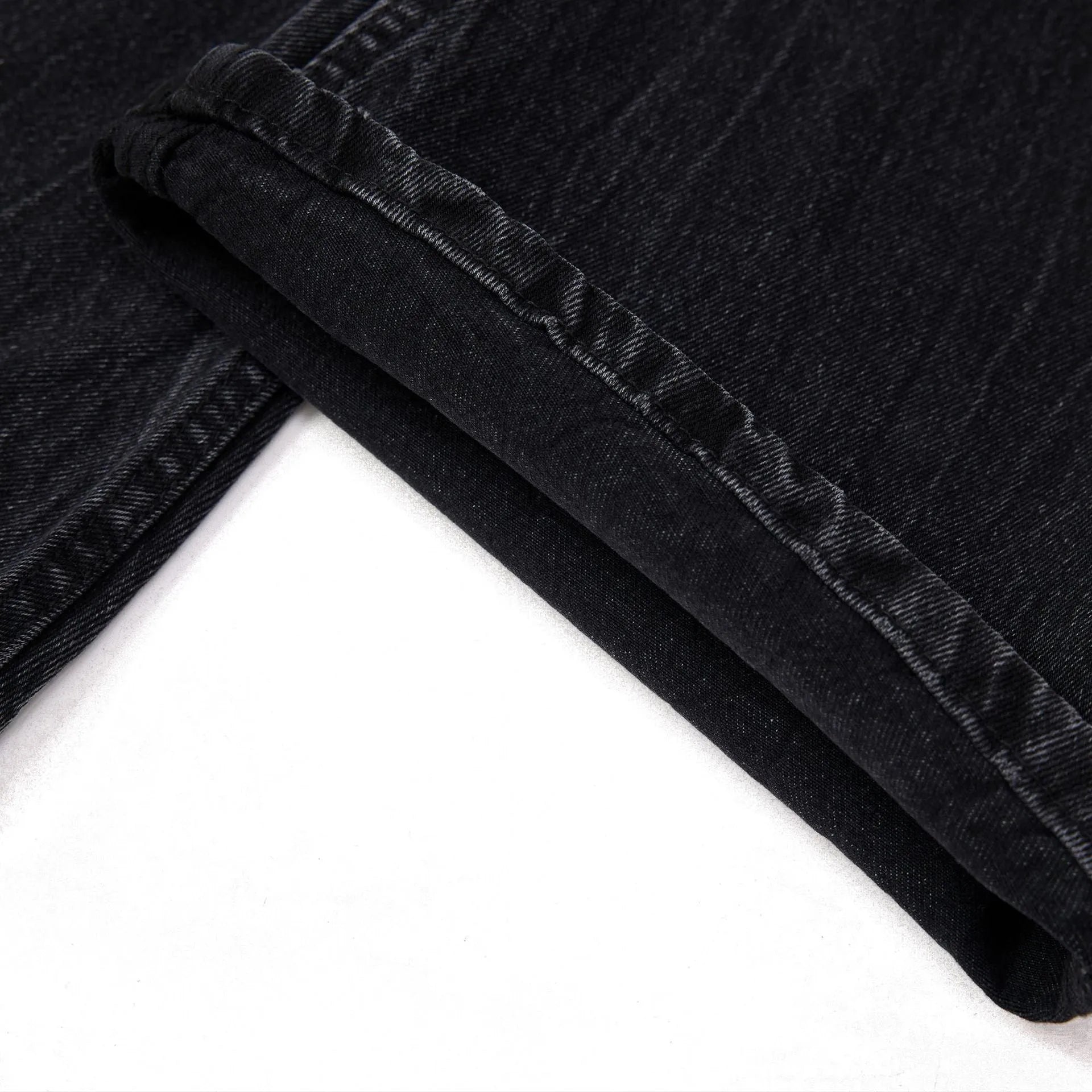 Men's straight-leg black jeans showing an American washed finish with a lightning crack pattern on the legs.
