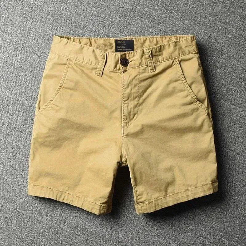 Men's loose straight-leg cotton shorts in solid colours on a hanger