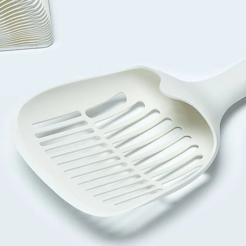 White plastic cat litter scoop sitting in its matching storage base.