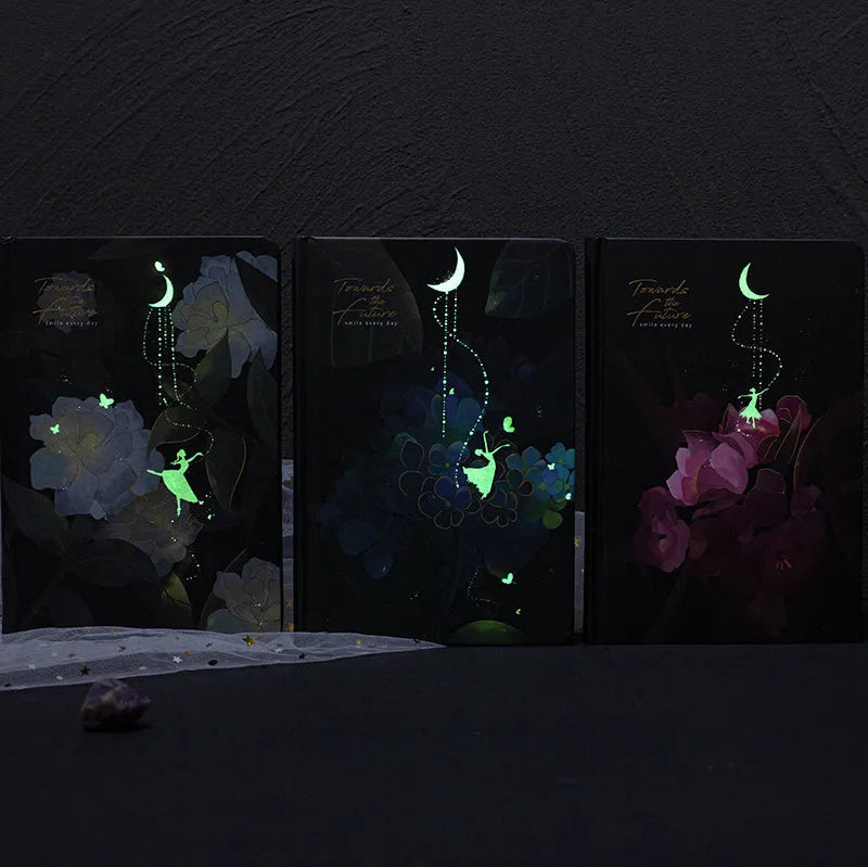 A5 notebook with a luminous cover open to show pages with colour illustrations.