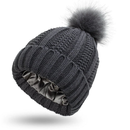 Cozy knit beanies with satin lining, paisley pattern, and faux fur pom poms in a variety of colors