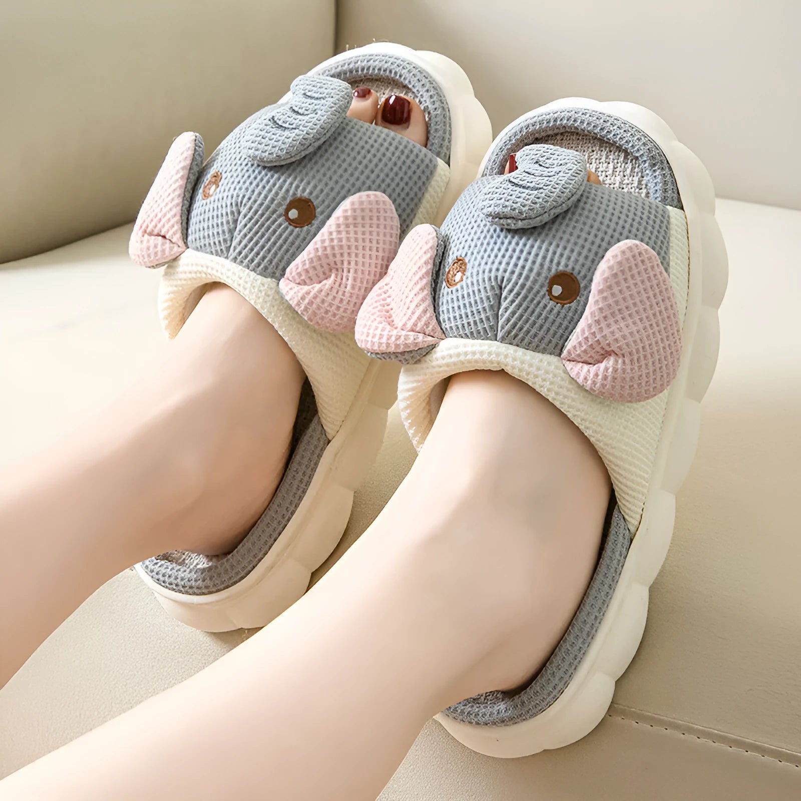 A pair of elephant grey open-toe linen slippers for couples on a plain background.