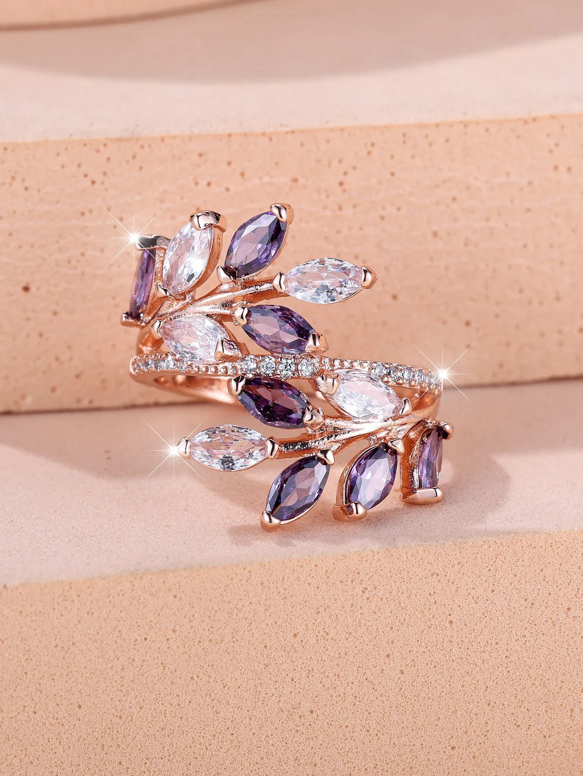 Adjustable copper leaf ring with a horse eye zircon stone in multiple colour finishes on a neutral background.