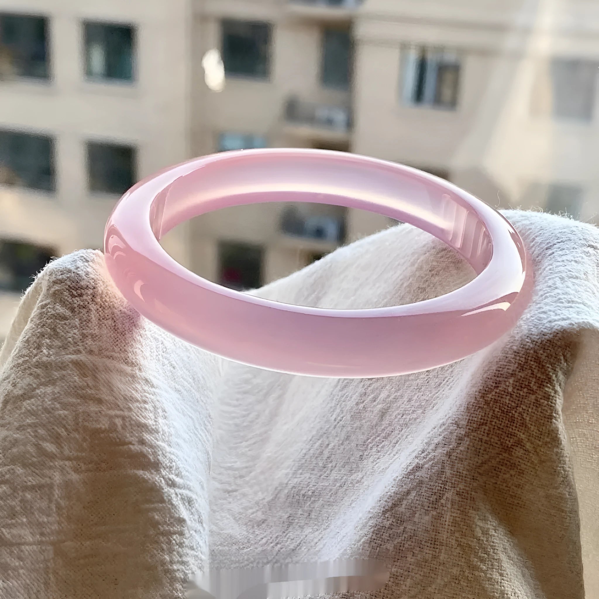 Natural agate wide tyre bead bracelet in pink, showing flat polished stone beads on a wrist.