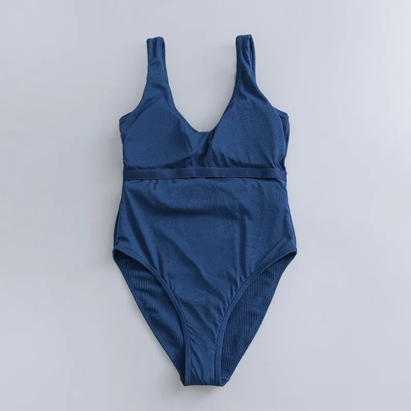 Navy blue one-piece women's swimsuit with a triangle neckline and slimming fit on a mannequin.