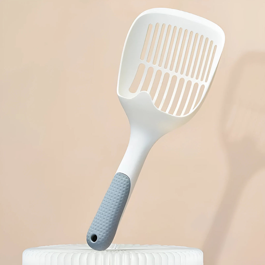 White plastic cat litter scoop sitting in its matching storage base.