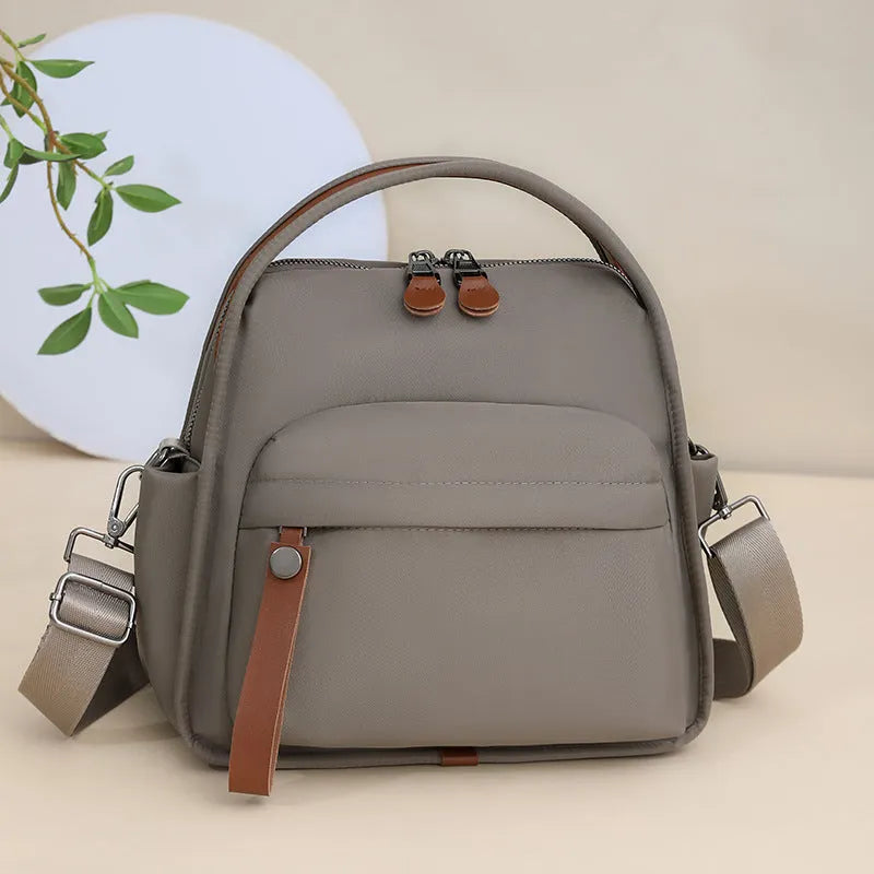 Nylon shoulder bag 25x11x23cm pillow shape with zippered compartment and outer pocket, available in brown, khaki, black, beige