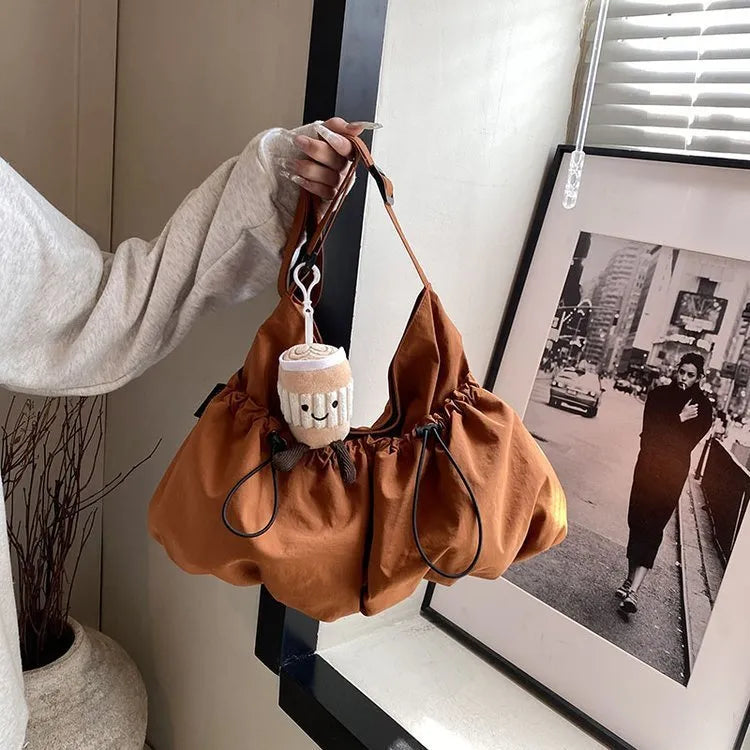 Ultra-light pleated crossbody student cloth bag in folded position showing split pocket design
