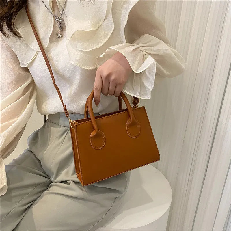 Small square shoulder bag in PU leather with single strap and document pocket, shown in available colours