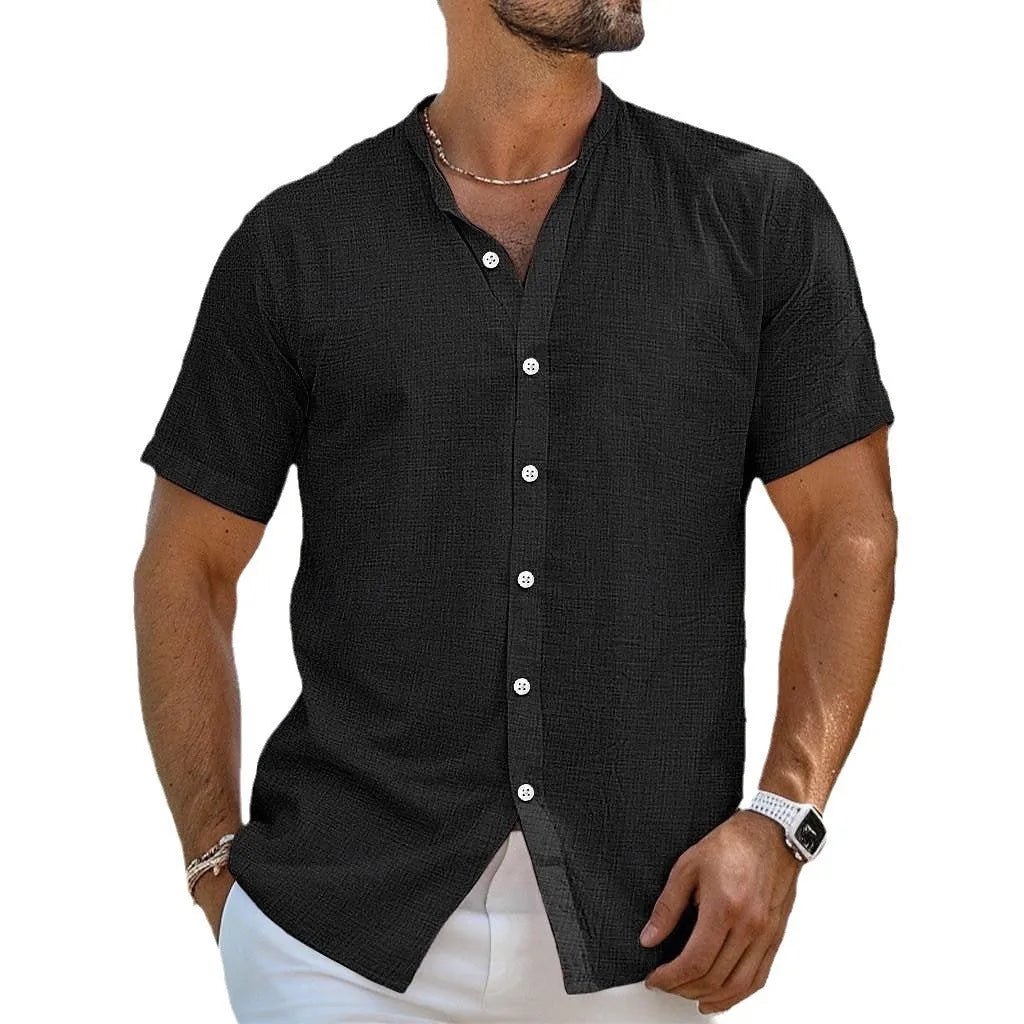 Man wearing a light blue loose fit short sleeve cardigan shirt with a henry collar.
