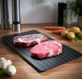 Black aluminium fast defrosting tray for kitchen use on a countertop