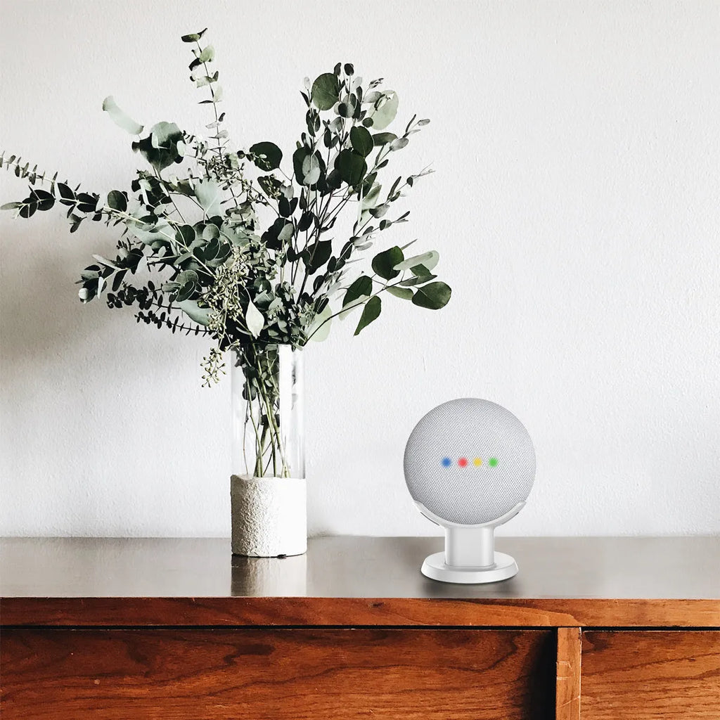 Black plastic stand holder for a Google Home Mini smart speaker on a desk