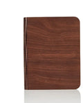 A solid wood adjustable LED book light on a desk next to a book.