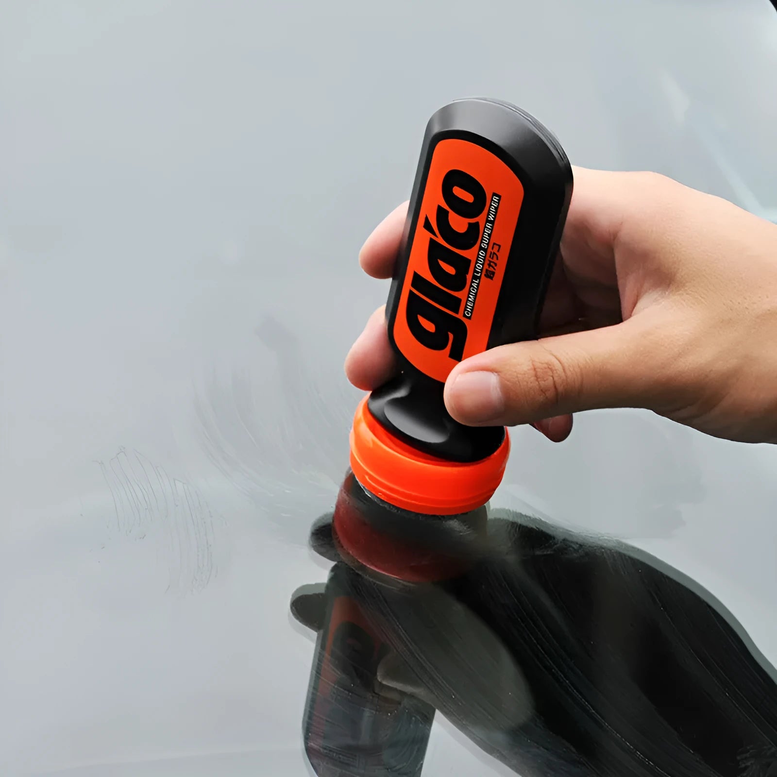 70ml bottle of transparent car windscreen rain repellent treatment on a car glass surface.