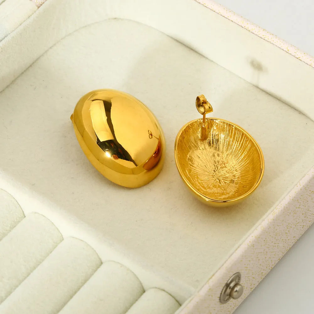 Geometric stainless steel ear studs with a gold electroplated finish and exaggerated glazed surface.