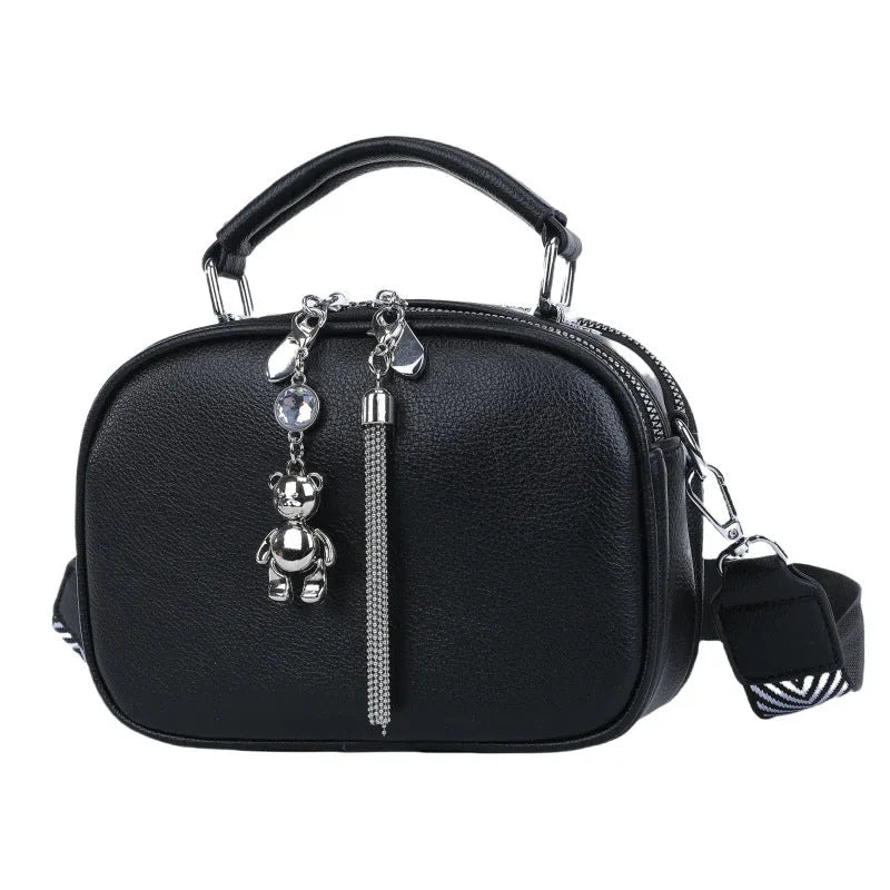 Women's small square stitching bag in oval shape with double shoulder strap showing internal mobile phone compartment.