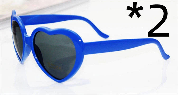 Heart-shaped glow-in-the-dark sunglasses in various vibrant colors, featuring a durable plastic frame and resin lenses for reliable UV protection.