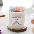 Aromatherapy candle with dried flowers embedded in the wax, shown next to its optional gift box packaging.