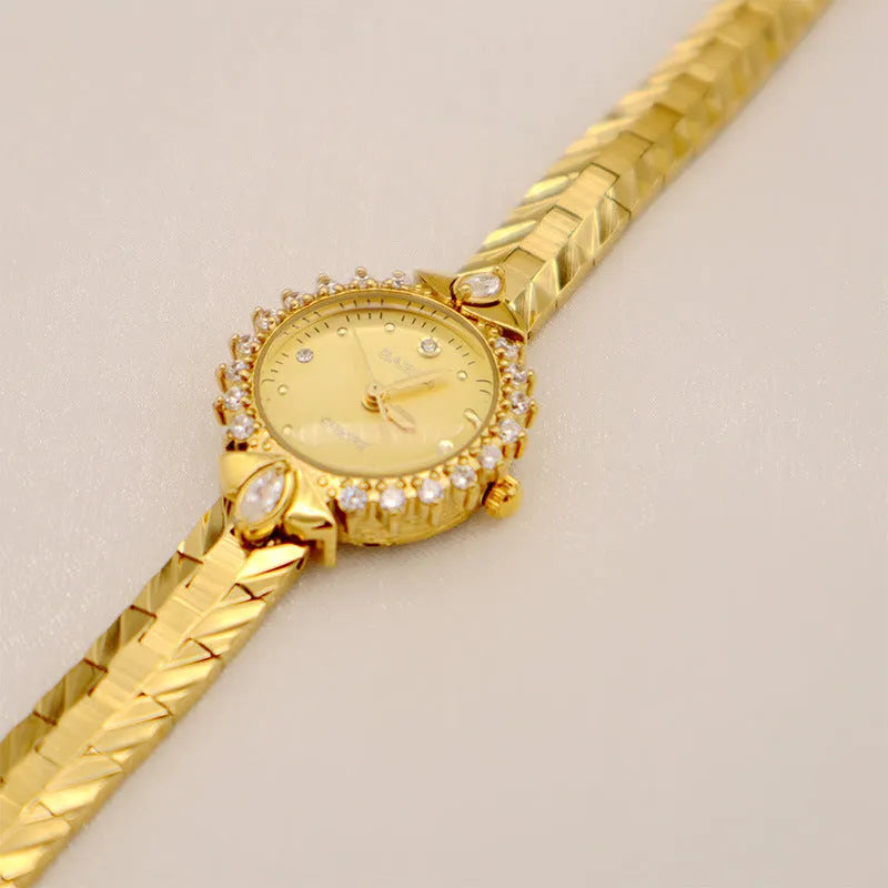 Women's vintage-style quartz watch with diamond-embossed dial and gold metal bracelet
