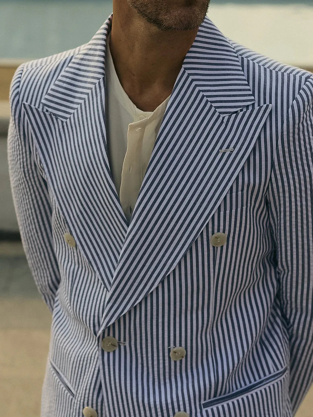Blue and white striped women's blazer and trouser suit set on a hanger