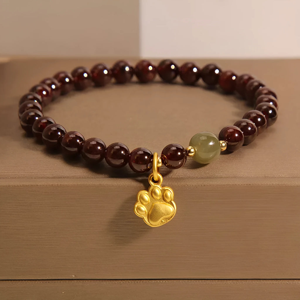Women's crystal bracelet with a cat's paw garnet motif on a wrist.