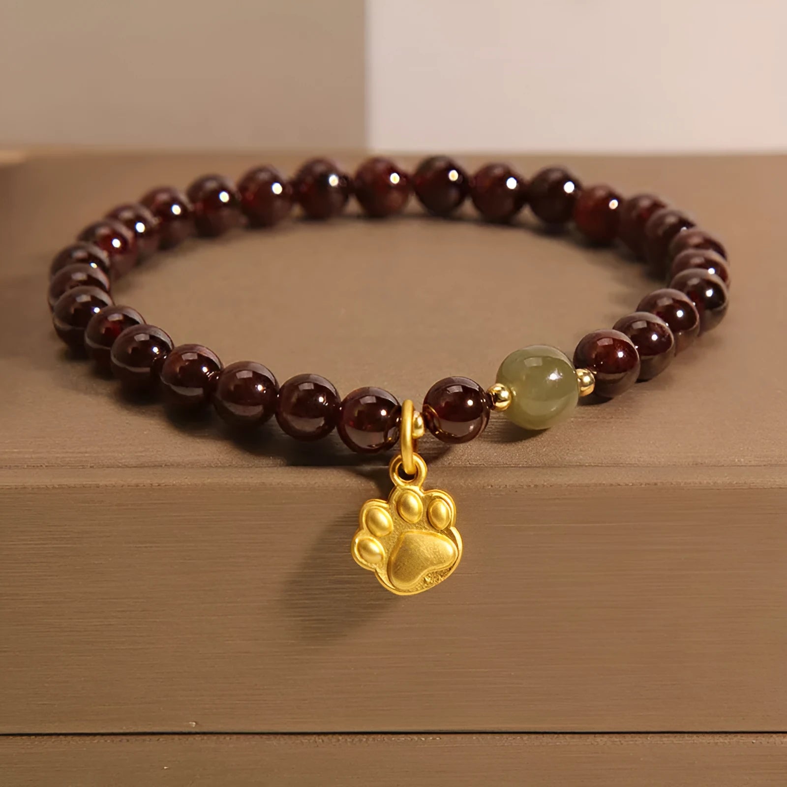 Women's crystal bracelet with a cat's paw garnet motif on a wrist.