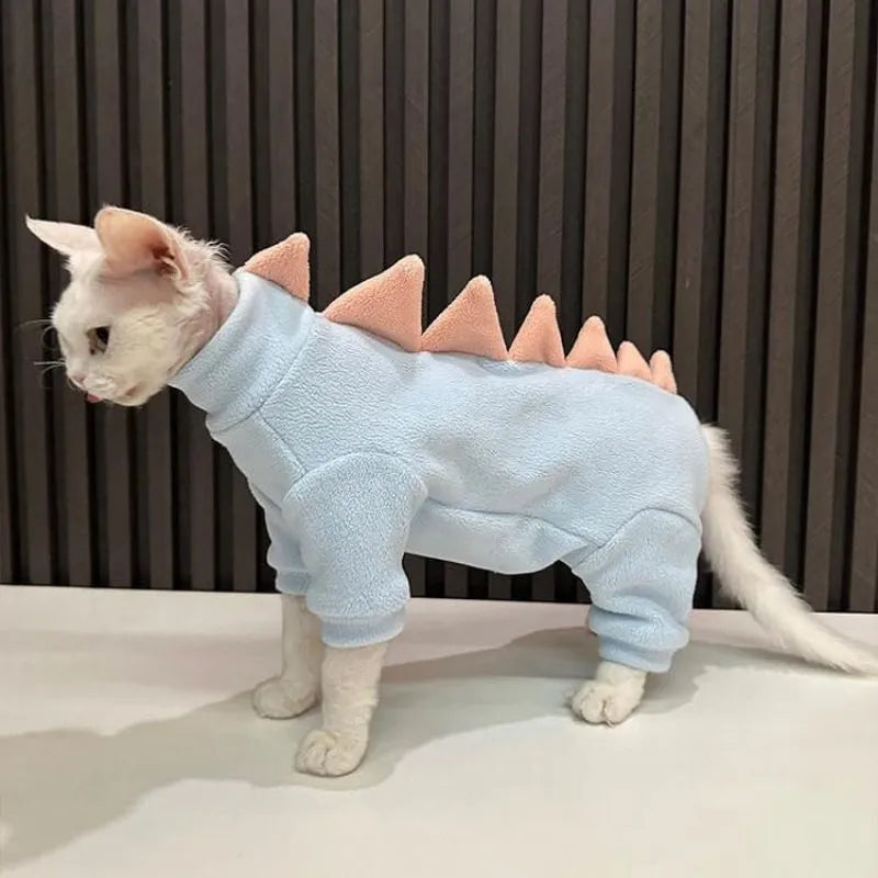 Sphynx cat wearing dinosaur costume with fleece material and tail spikes