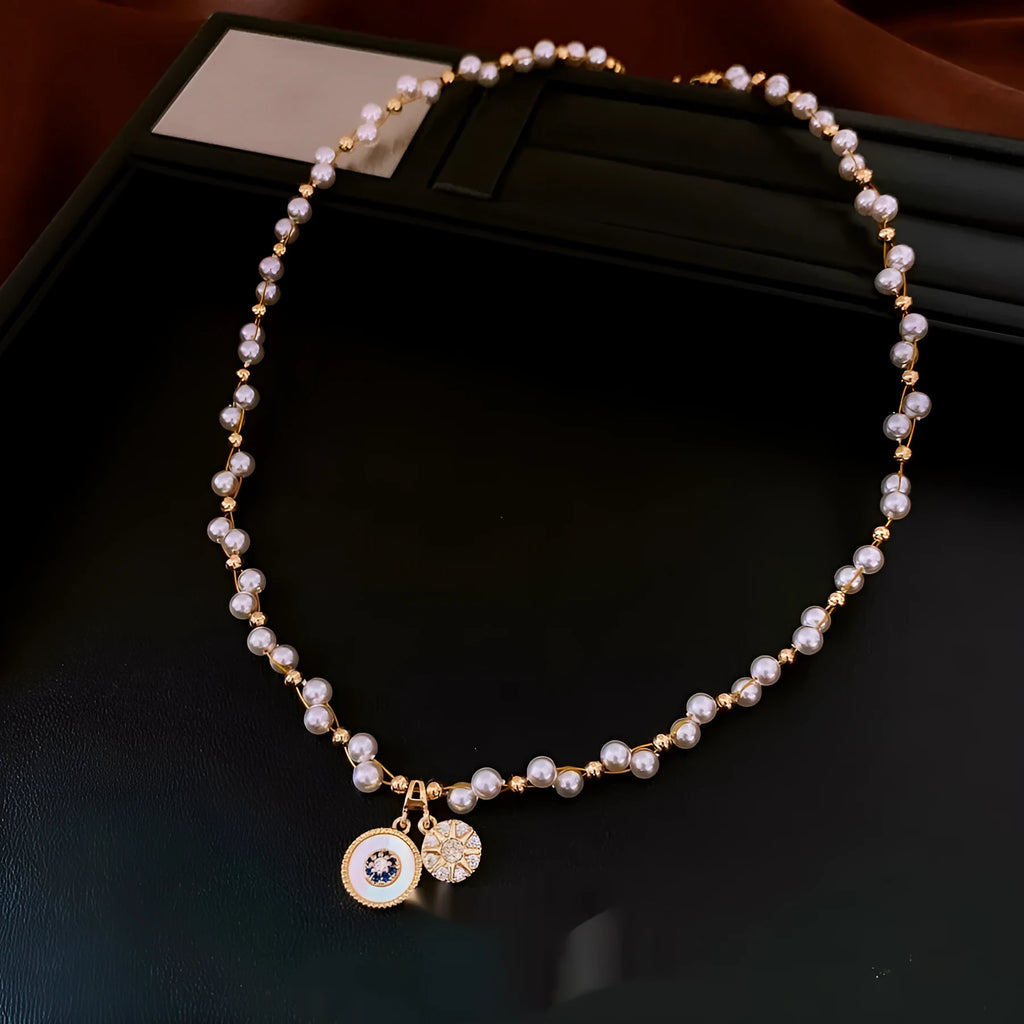 Gold and white electroplated necklace with round pearl pendant and zircon detailing on clavicle chain
