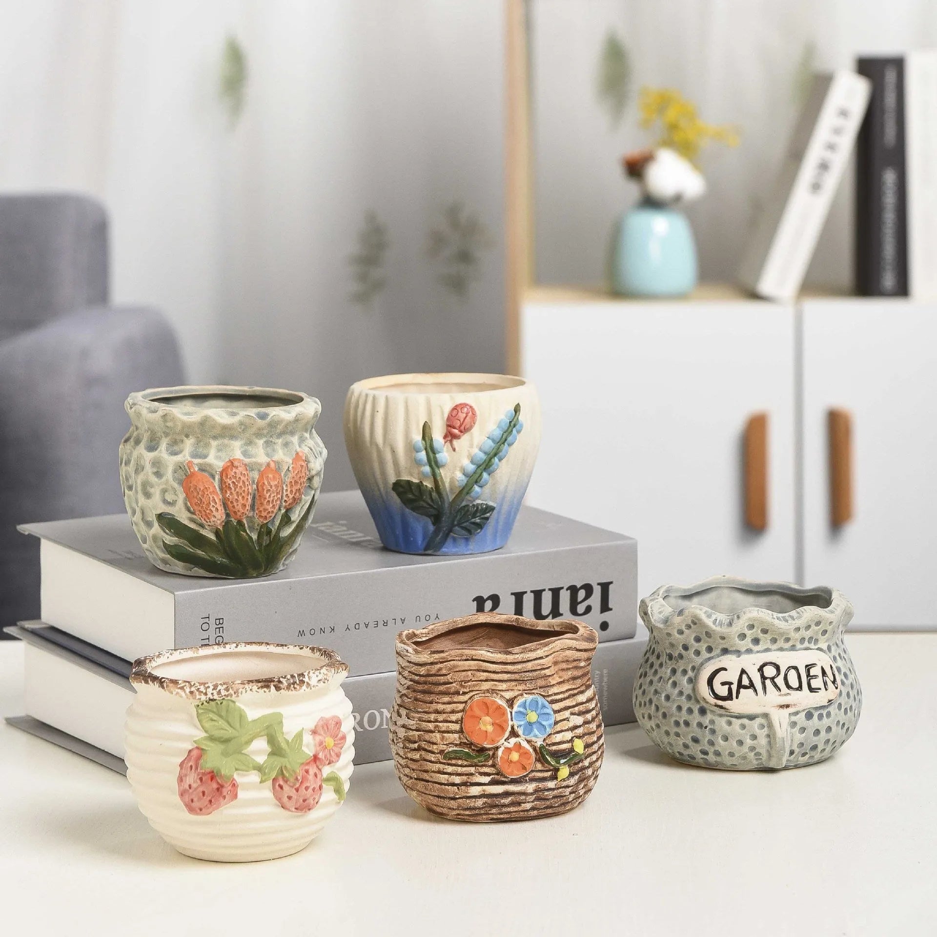 Three breathable stoneware succulent flower pots in hand-painted glaze colours on a tabletop with small succulents inside