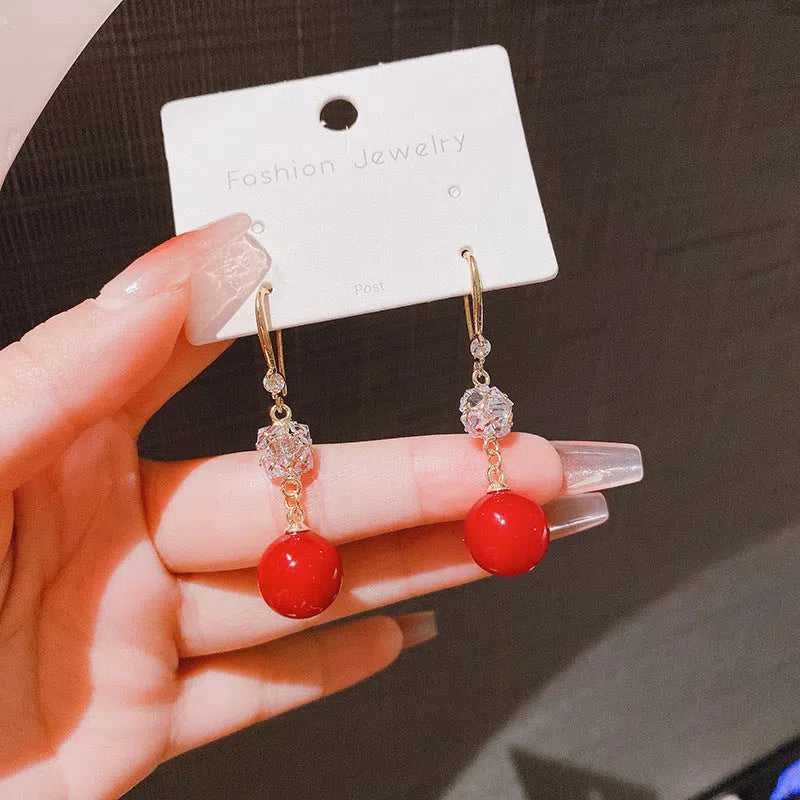 Personalised pearl earrings with red bean accent in a drop style, available in two options.