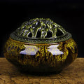 Ceramic incense burner with retro packaging in various colours on wooden surface.