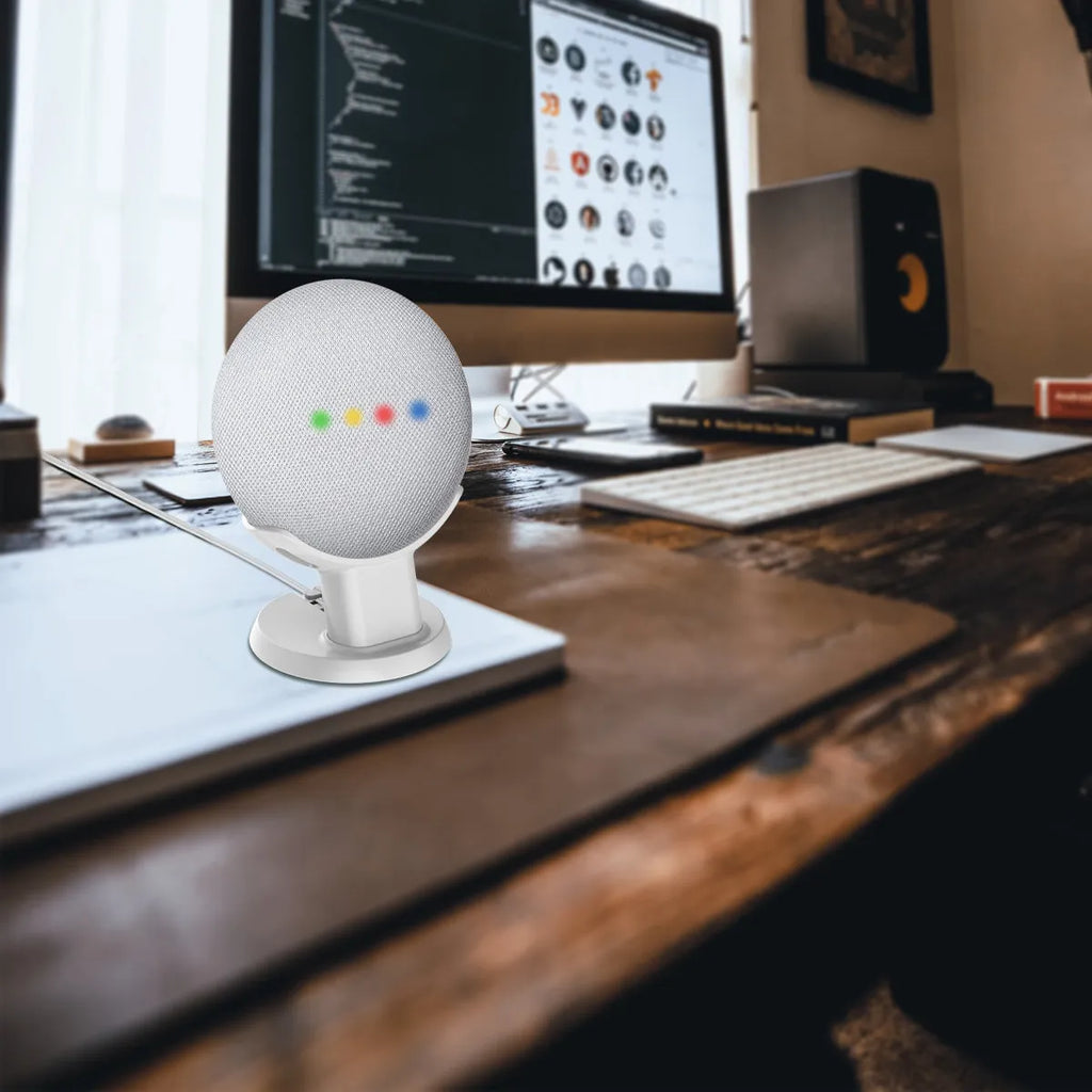 Black plastic stand holder for a Google Home Mini smart speaker on a desk