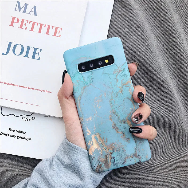 Samsung Galaxy phone in a hard PC back cover case with a white and grey marble pattern design.